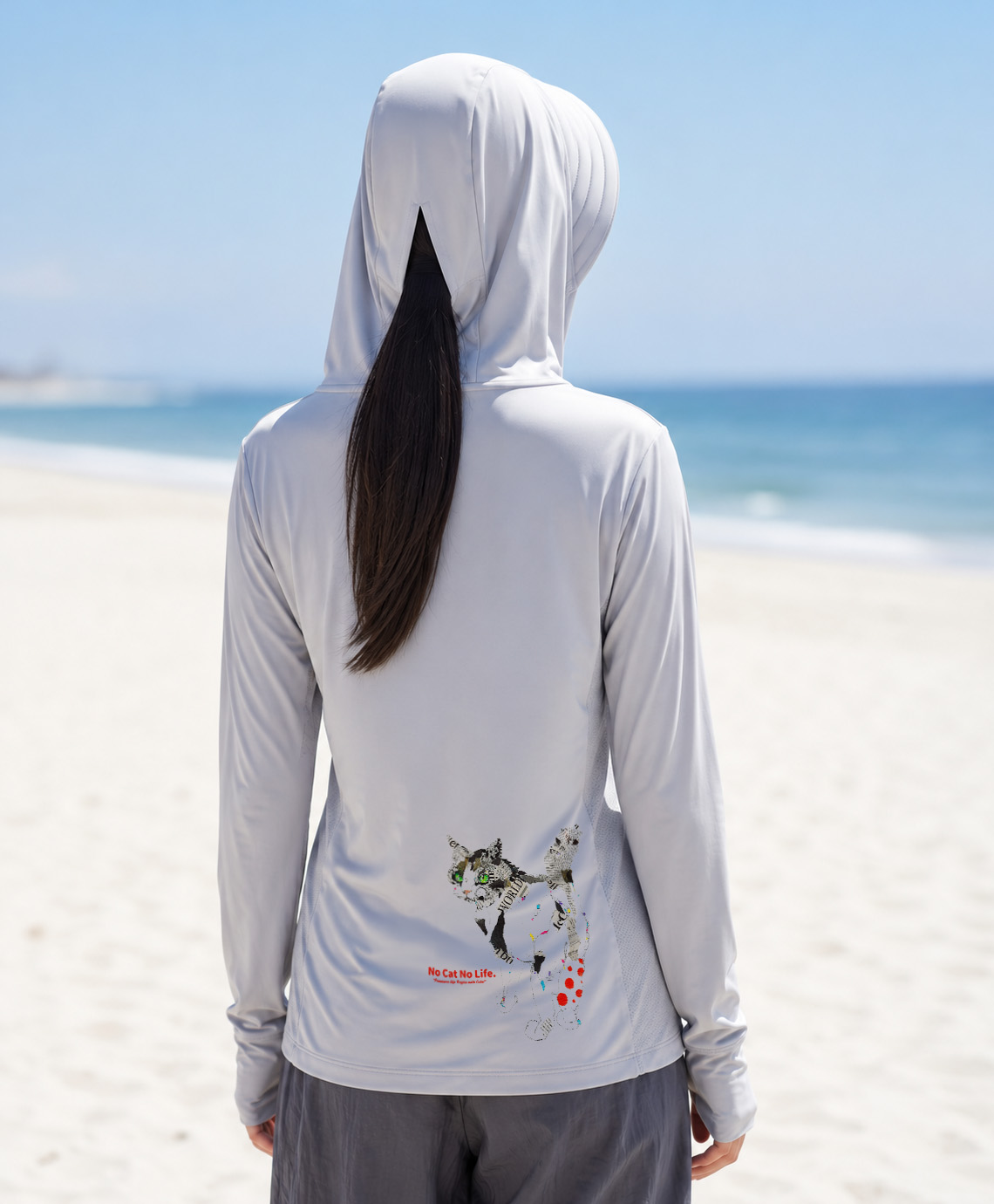 フードからポニーテールが出ている後ろ姿・グレーのNEKONI UV HOODIE着用